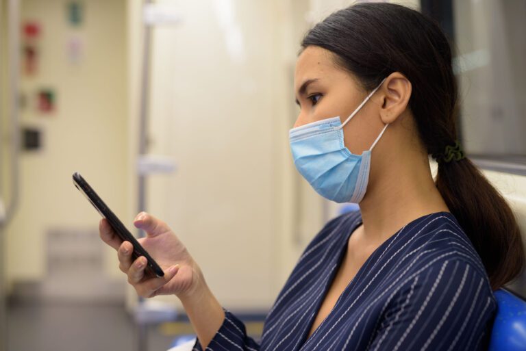 Portrait of young Asian businesswoman with mask for protection from corona virus outbreak at the subway train station