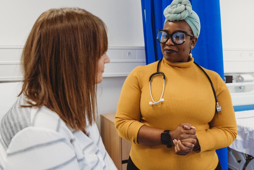 Healthcare worker with multiple disabilities (Long Covid) talks to a patient who has a mental health condition.
