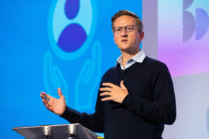 Man giving speech onstage at a conference.