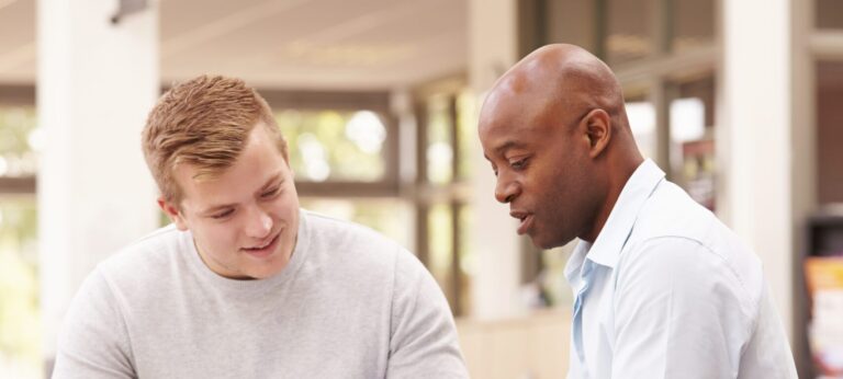 2 people looking at a tablet. Above them is a sign that reads 'Services'.