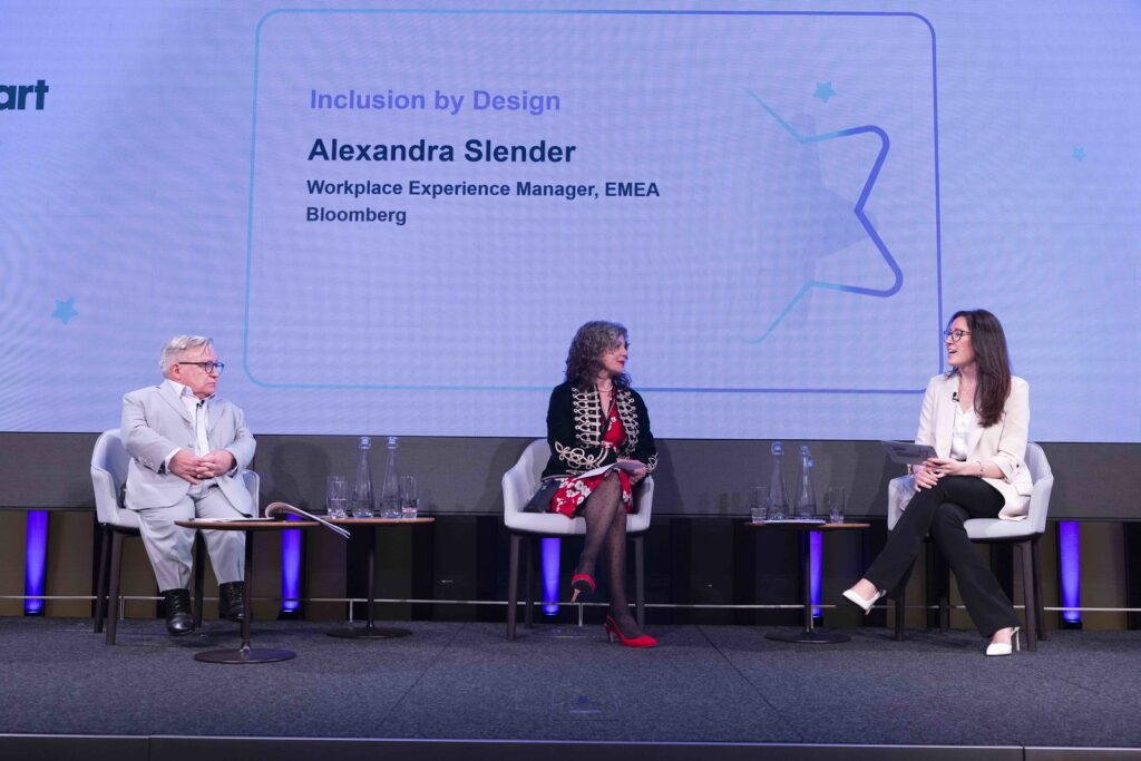 Cost hosts Simon Minty and Diane Lightfoot sitting in chairs on stage in conversation with speaker Alexandra Slender at the Disability Smart Awards 2024 ceremony.