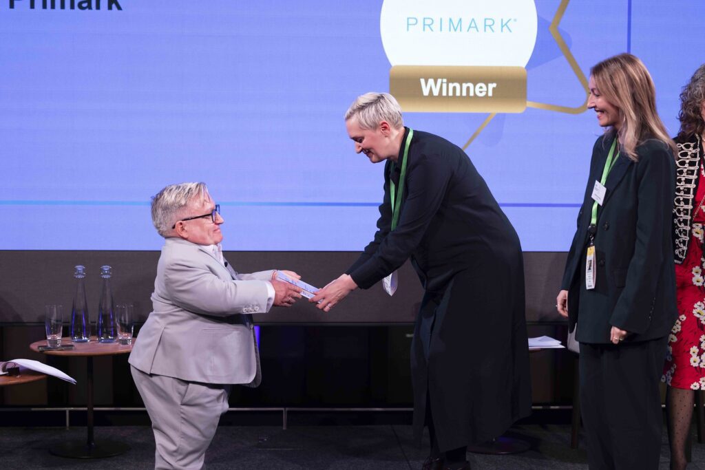 A winner receives their award from the host on stage at the Disability Smart Awards 2024 ceremony.