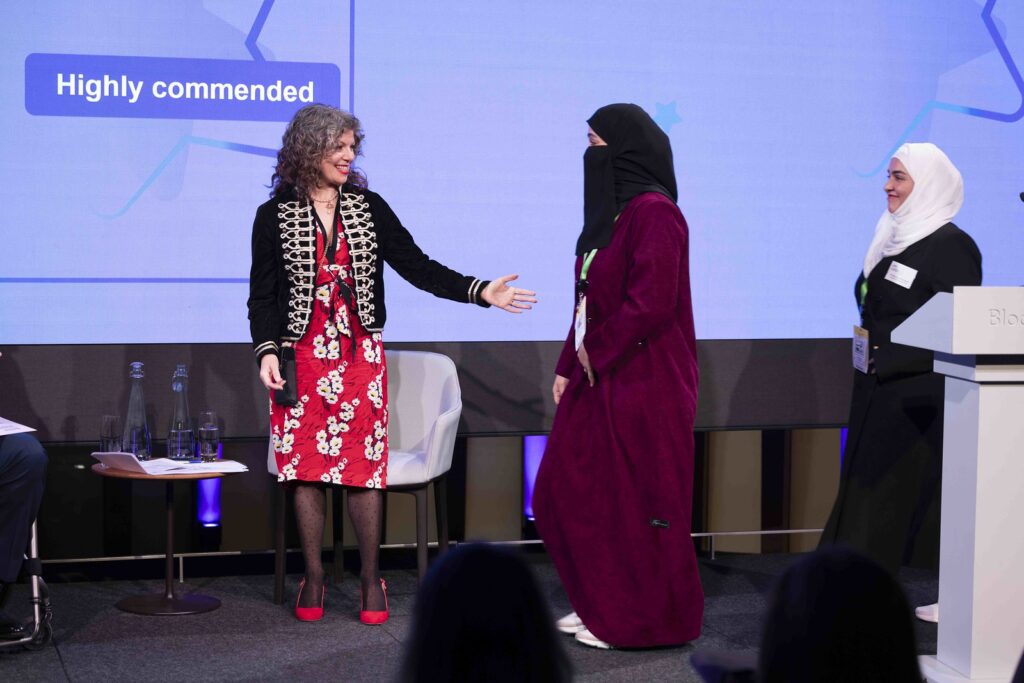 Diane Lightfoot welcomes 2 winners on stage at the Disability Smart Awards 2024 ceremony.