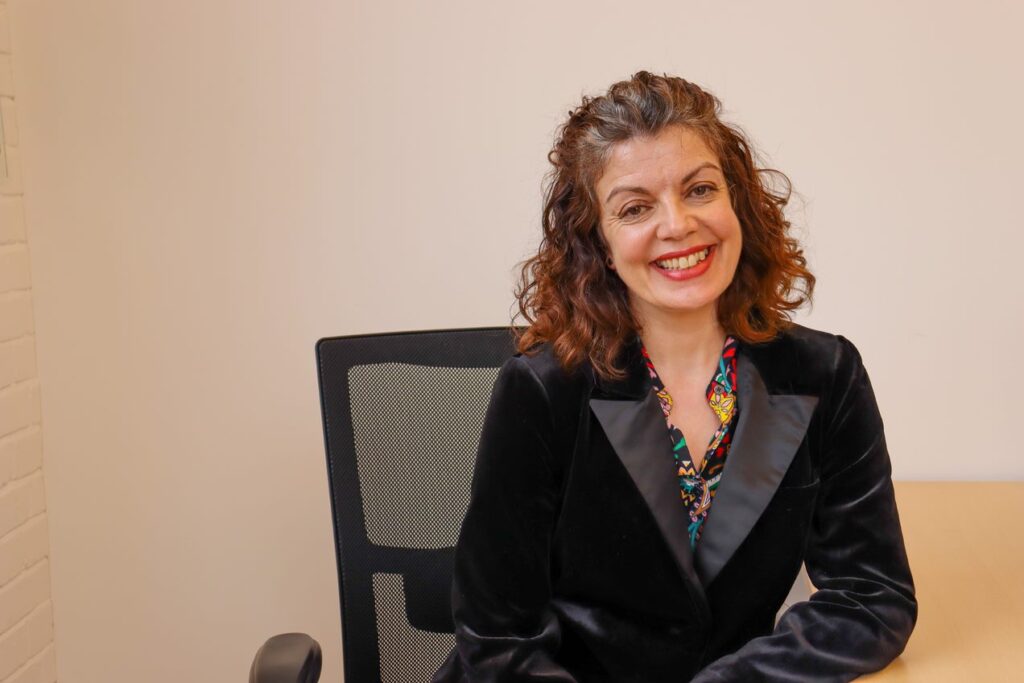 Headshot of Diane Lightfoot, CEO of Business Disability Forum. She's a white woman with mid-length brown hair. In the photo she is wearing a black blazer and sitting at a desk.