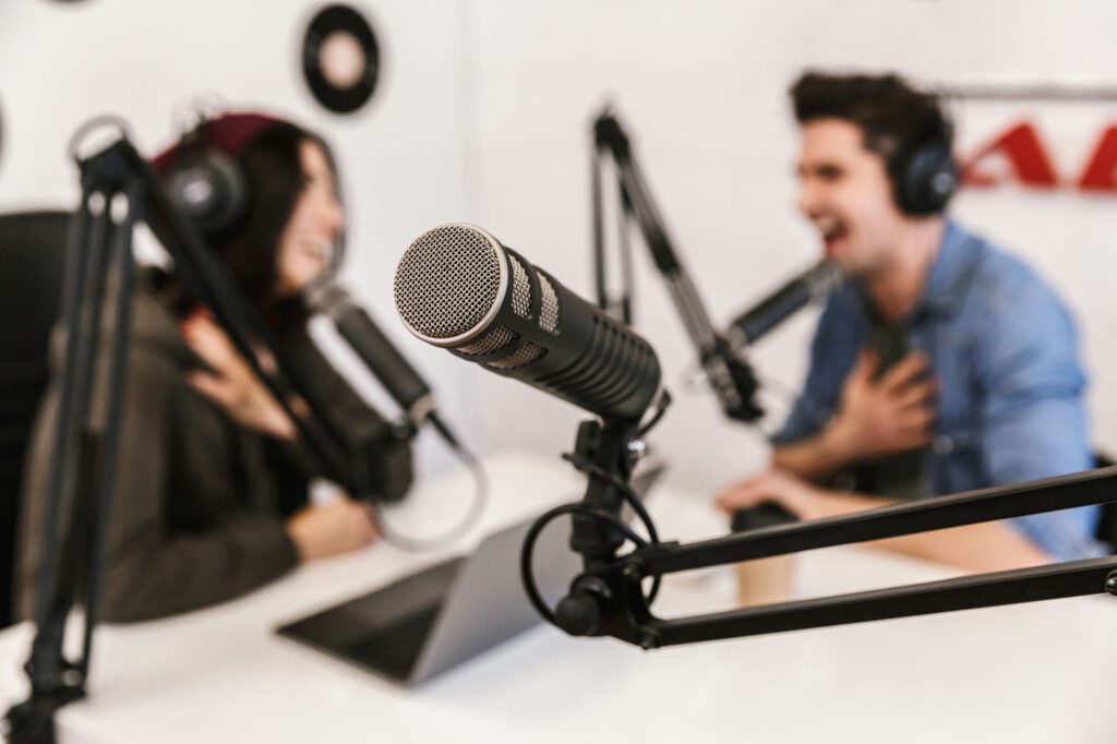 Image of two people recording a podcast