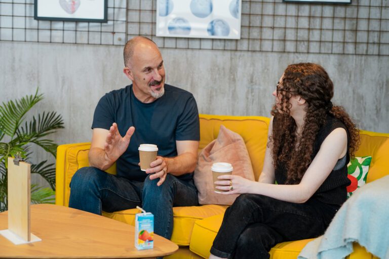 A man with a hearing impairment has a coffee with a friend