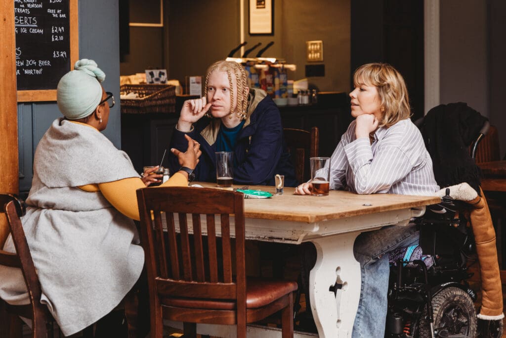 Friends with multiple disabilities chat in the pub