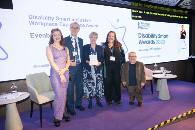 The Evenbreak team posing with their award on stage at the Disability Smart Awards 2023 ceremony.