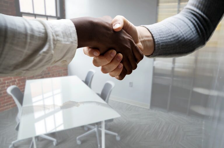 Close up on a handshake in a meeting room.