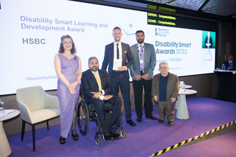 The HSBC team posing with their award on stage at the Disability Smart Awards 2023 ceremony.