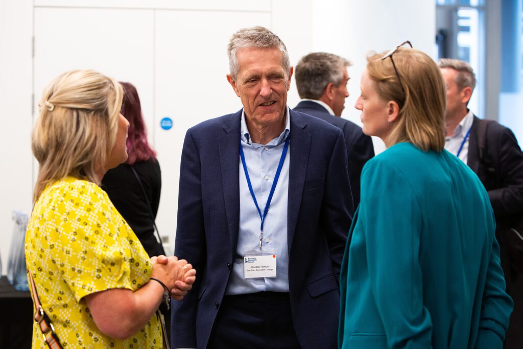 Three guests network at an event.