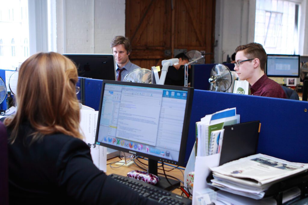 Image of the BDF office, three colleagues all working on desktops