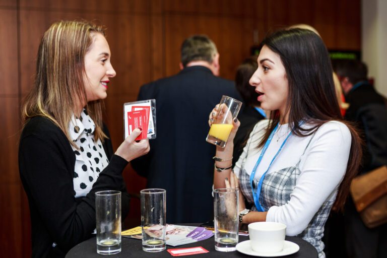 Two women talking at a Business Disability Forum conference.