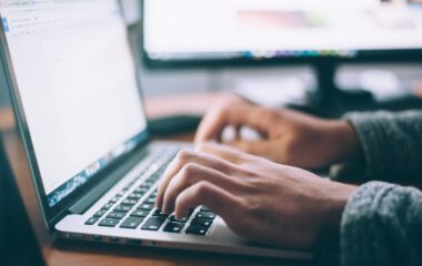 A person typing on a laptop keyboard