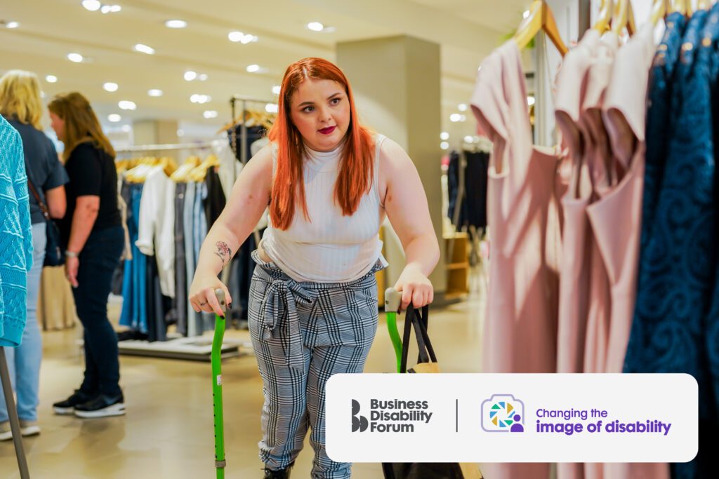 Young woman with cerebral palsy uses walking sticks to help her shop for clothes.