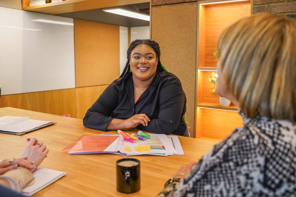 Person with less-visible disabilities meets with colleagues at a table