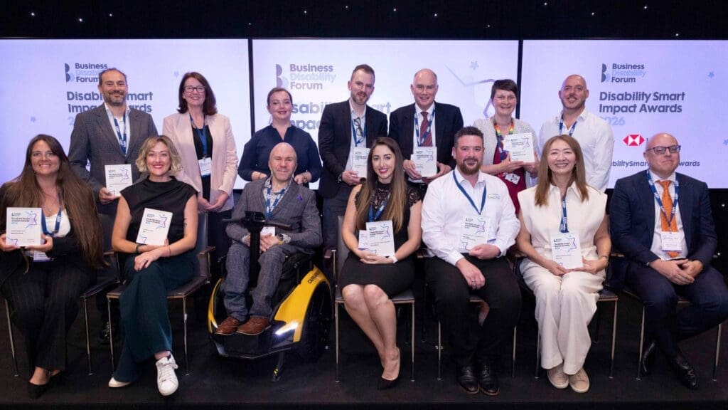 Group photo of multiple award winners holding trophies at the Disability Smart Impact Awards 2026.